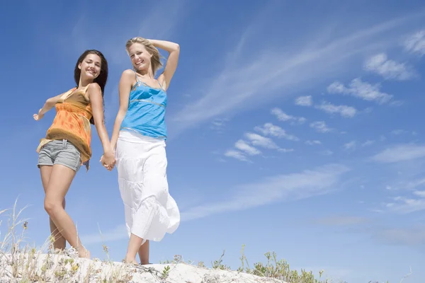 Två unga kvinnor avkopplande på stranden — Stockfoto