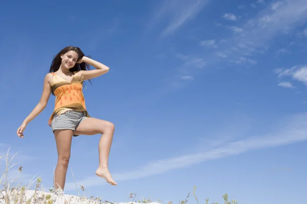 年轻女人放松在海滩反对蓝蓝的天空 — 图库照片