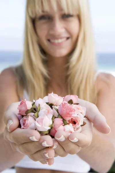 ピンクの花の芽の一握りを保持している女性 — ストック写真