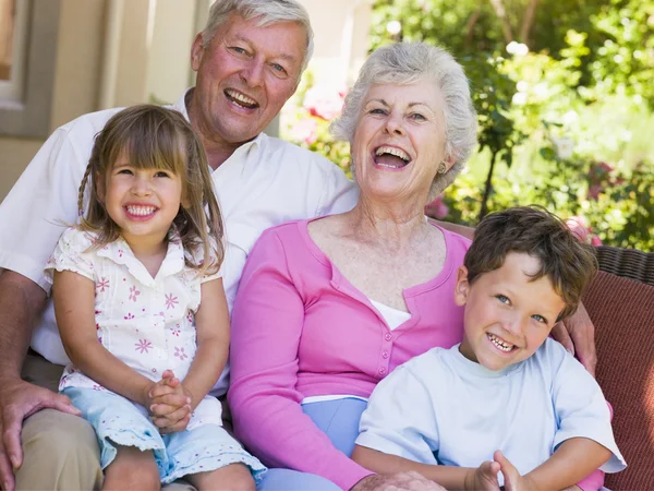 Бабушка и дедушка смеются вместе с внуками — стоковое фото