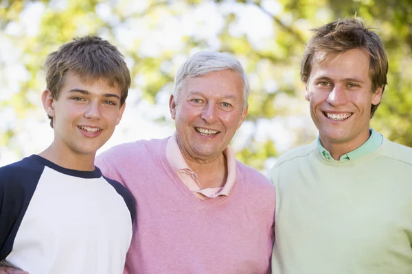 Дедушка с сыном и внуком улыбаются — стоковое фото