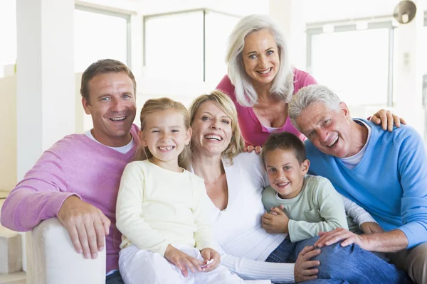 Сім'я сидить у приміщенні посміхаючись — стокове фото