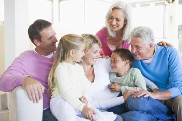 Rodina sedí doma s úsměvem — Stock fotografie