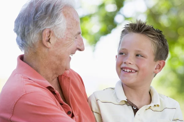 Dziadek i wnuczek uśmiechający się na zewnątrz. — Zdjęcie stockowe