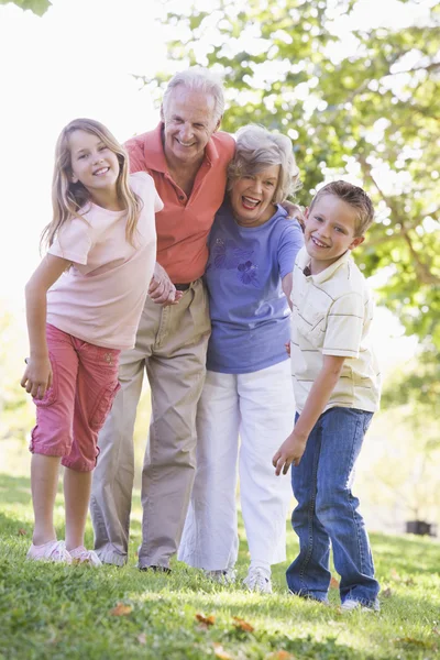 Бабушка и дедушка смеются вместе с внуками — стоковое фото