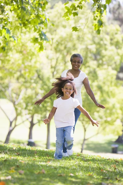 祖母と孫娘公園で走っていると笑みを浮かべて — ストック写真