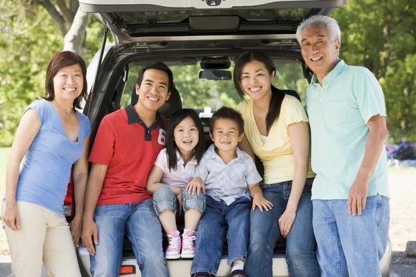 Расширенная семья, сидящая в задней части автомобиля — стоковое фото