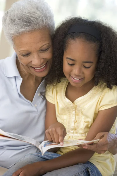Büyükanne ve genç gülümseyen ve okuma — Stok fotoğraf