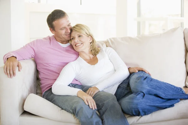Casal relaxante na sala de estar e sorrindo — Fotografia de Stock