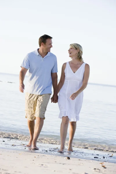 情侣在海滩牵手和微笑 — 图库照片
