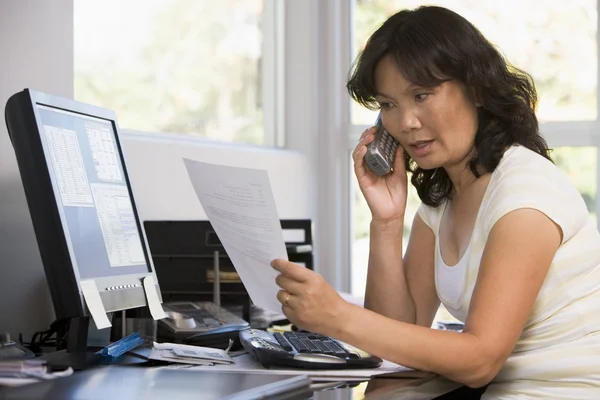 Kobieta w domowym biurze z dokumentów przy użyciu telefonu — Zdjęcie stockowe