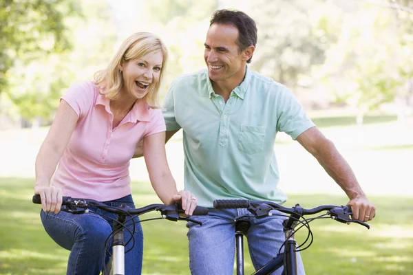 Пара на велосипедах на улице улыбается — стоковое фото