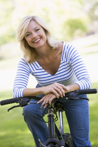 Woman on bike outdoors smiling — Stock Photo, Image