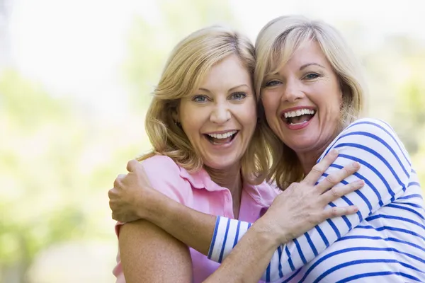 Two Women Outdoors Hugging Smiling — Stock Photo, Image