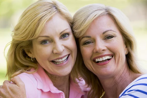 Две женщины на улице обнимаются и улыбаются — стоковое фото