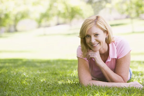 Vrouw ontspannen buitenshuis glimlachen — Stockfoto