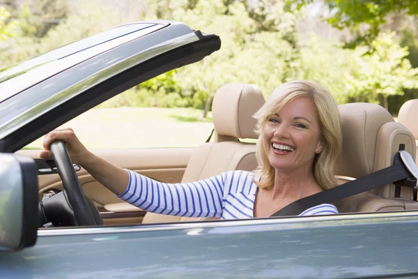 Mujer en coche descapotable sonriendo — Foto de Stock