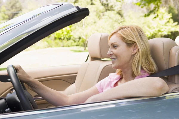 Vrouw in een convertible auto glimlachen — Stockfoto