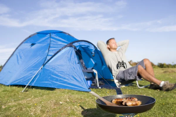 Man camping outdoors and cooking — Stock Photo, Image