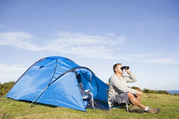 Homem acampar ao ar livre e olhando através de binóculos — Fotografia de Stock