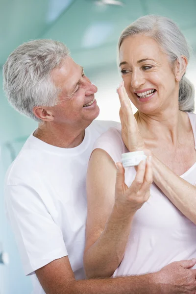 Couple Embracing Spa Holding Cream Smiling — Stock Photo, Image