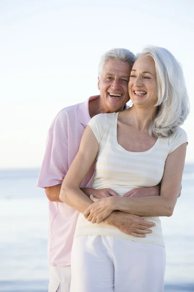 Par på stranden embracing och leende — Stockfoto
