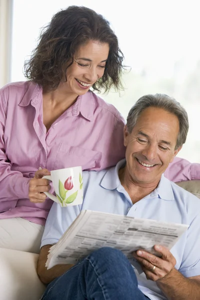 Par avkopplande med en tidning leende — Stockfoto