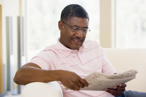 Homme relaxant avec un journal souriant — Photo