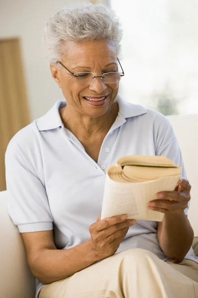 Mulher relaxante com um livro e sorrindo — Fotografia de Stock