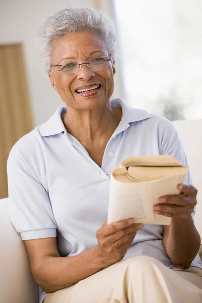 Mujer relajándose con un libro y sonriendo — Foto de Stock