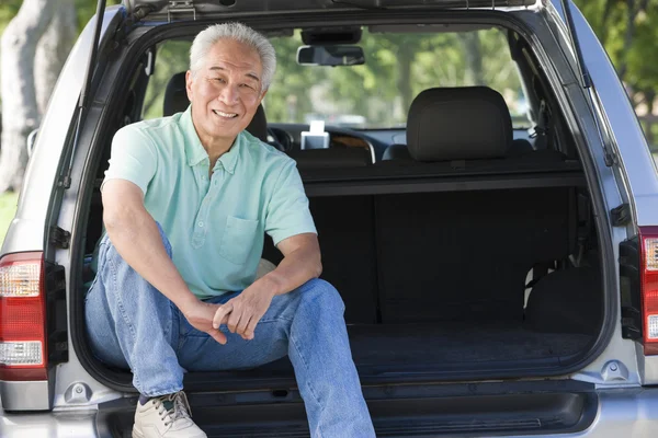 Человек, сидящий на заднем сиденье фургона и улыбающийся — стоковое фото