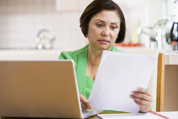 Woman Kitchen Laptop Paperwork Looking Worried — Stock Photo, Image
