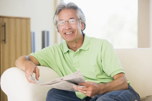 Homem relaxante com um jornal sorrindo — Fotografia de Stock