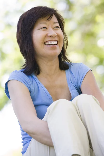 笑顔で屋外に座っている女性 — ストック写真