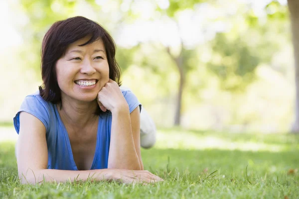 Vrouw ontspannen buitenshuis glimlachen — Stockfoto