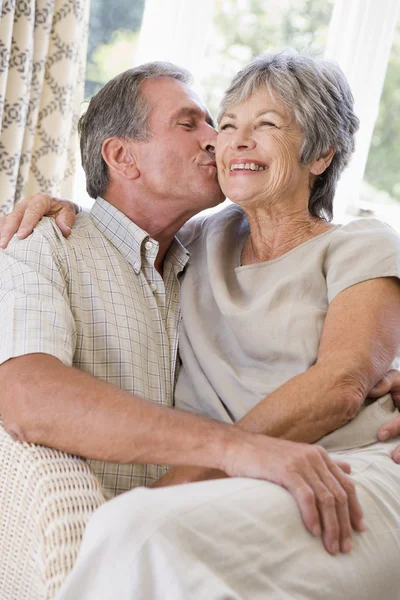 Par avkopplande i vardagsrum kyssar och leende — Stockfoto