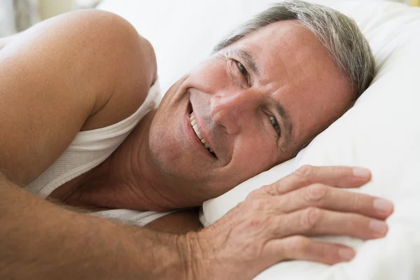 Άντρας Ξαπλωμένος Στο Κρεβάτι Χαμογελώντας — Φωτογραφία Αρχείου