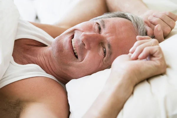 Άντρας Ξαπλωμένος Στο Κρεβάτι Χαμογελώντας — Φωτογραφία Αρχείου
