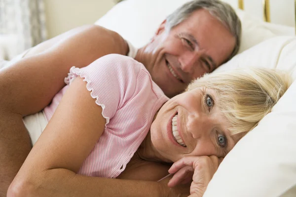 笑みを浮かべてベッドで横になっているカップル — ストック写真