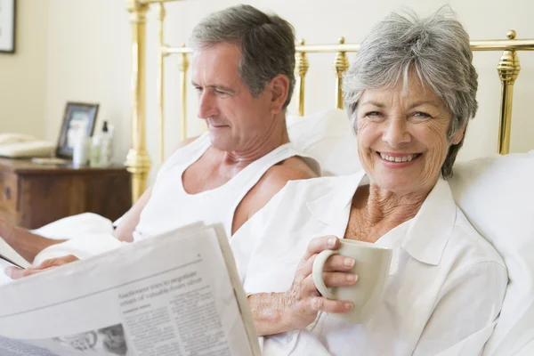 コーヒー 新聞の笑みを浮かべて寝室のカップル — ストック写真