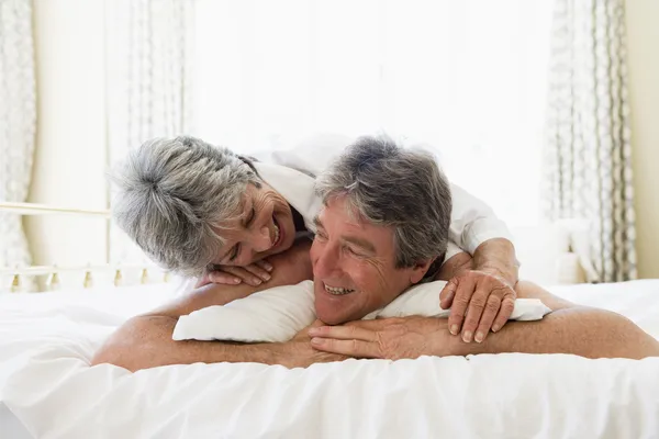 Couple relaxing in bedroom and smiling — Stockfoto