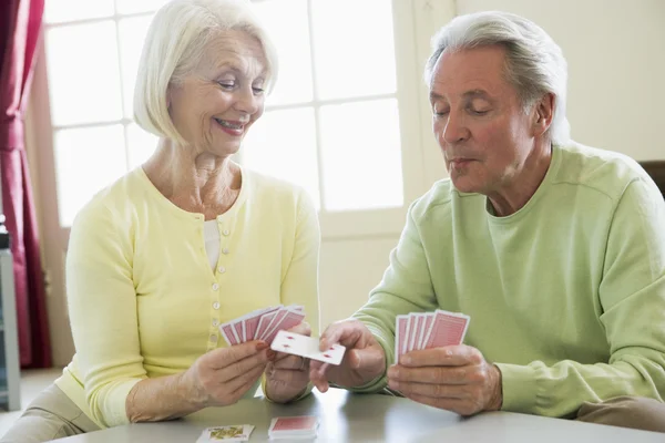 Couple playing cards in living room smiling — Stock Photo, Image
