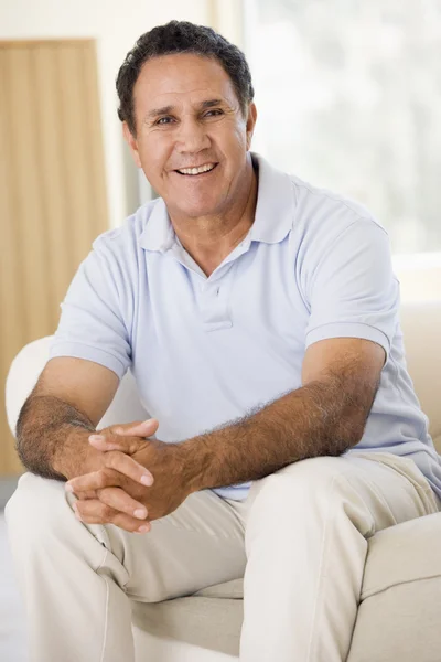 Mann im Wohnzimmer lächelt — Stockfoto