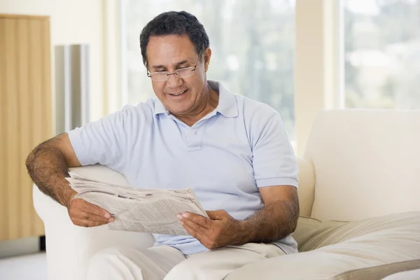 Muž Obývacím Pokoji Čtení Novin Úsměvem — Stock fotografie