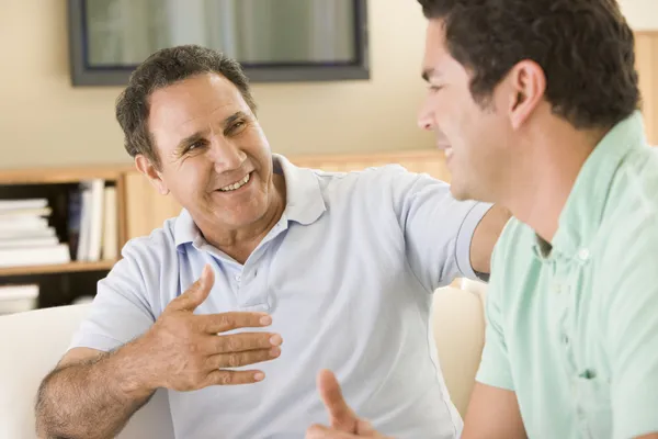 Dois homens na sala de estar falando e sorrindo — Fotografia de Stock