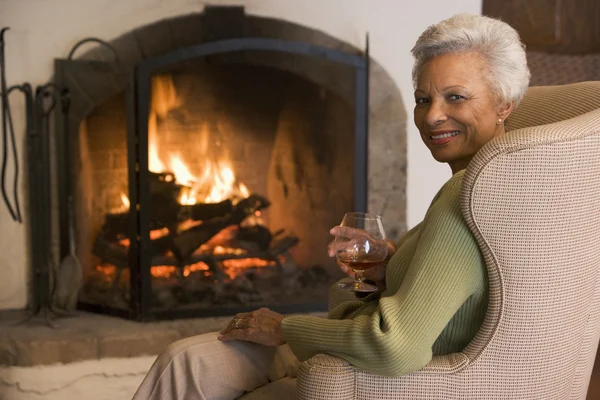 Vrouw in woonkamer met drankje lachende — Stockfoto