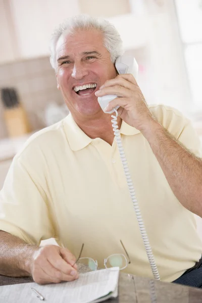 Adam gülüyor telefon üzerinde mutfak — Stok fotoğraf