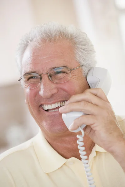 Człowiek za pomocą telefonów i uśmiechając się — Zdjęcie stockowe