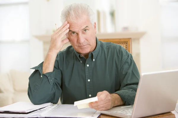 Mann Esszimmer Mit Laptop Und Papierkram Sieht Frustriert Aus — Stockfoto