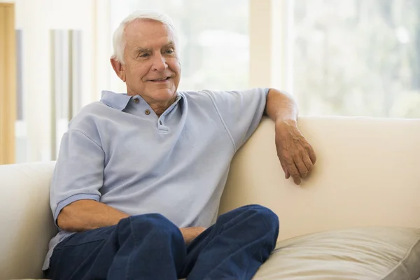 Man sitting in living room smiling — Stock Photo, Image